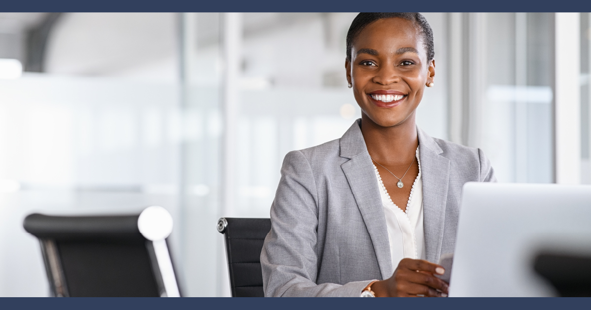 Woman in suit at desk smiling