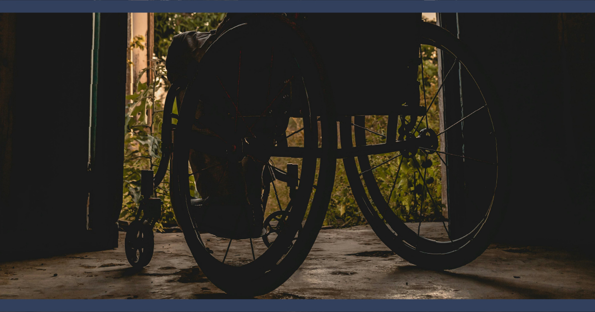 Person in wheelchair looking at the outside world from indoors