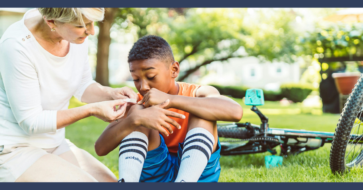 Child having arm checked by dult after a bicycle accident