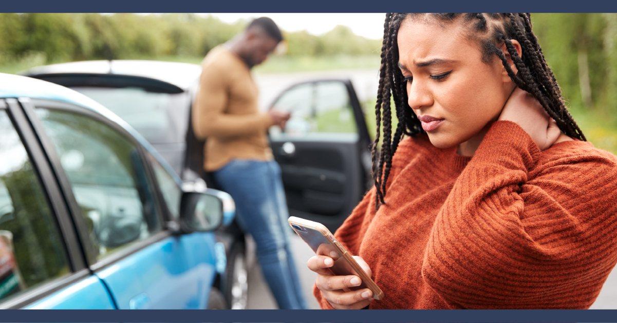 Two people after a car crash on their phones by their cars