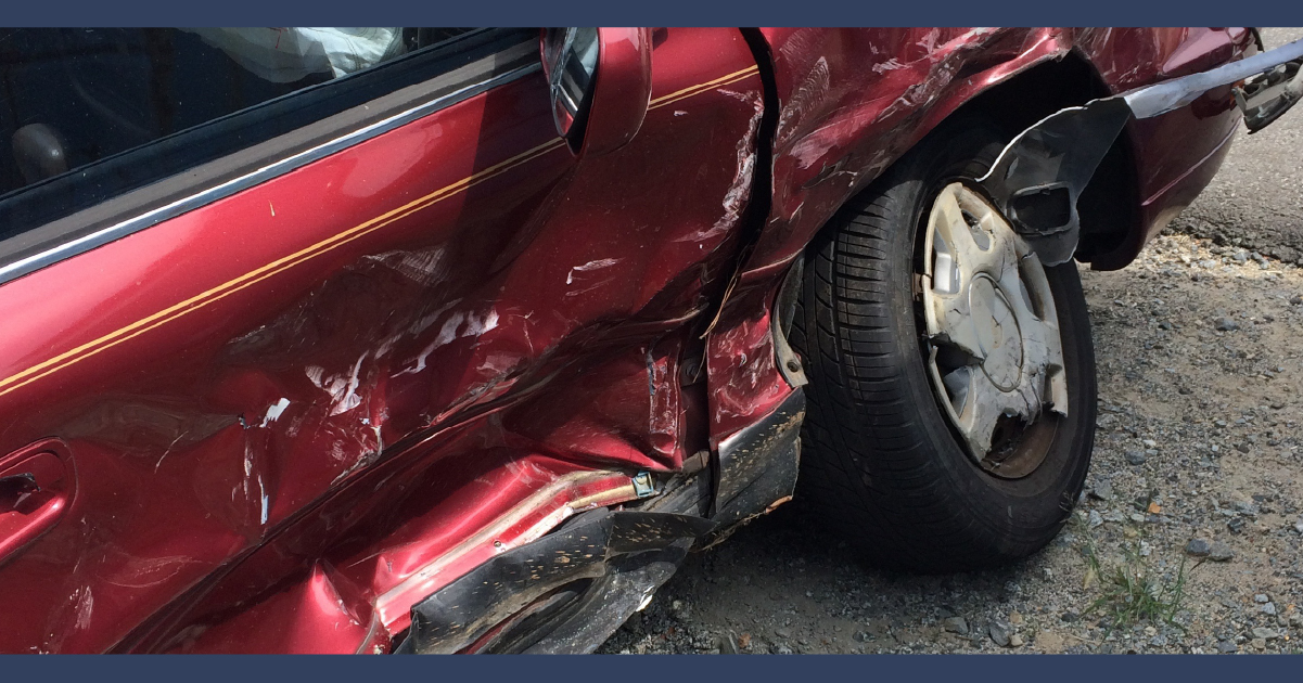 Side of red car showing impact damage